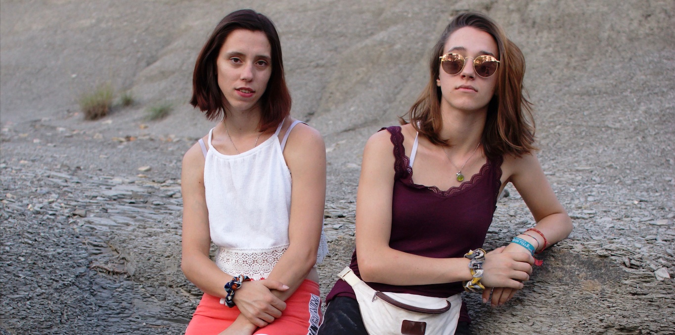 photo de deux jeunes filles adossées à un mur rocheux