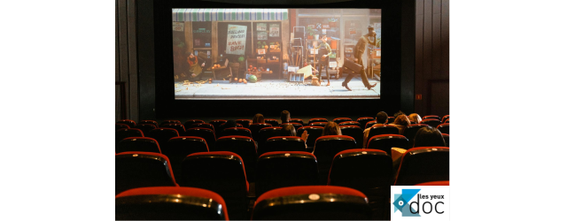 salle de cinéma montrant un film avec le logo des yeux docs en bas à droite