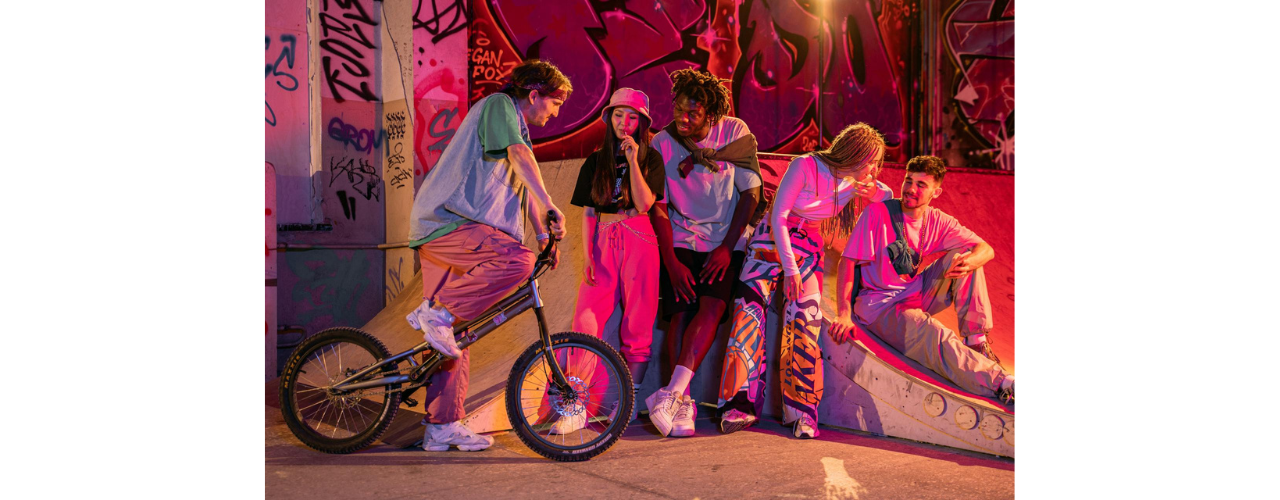 groupe de jeunes assis sous une lumière rose dans une ambiance streetwear